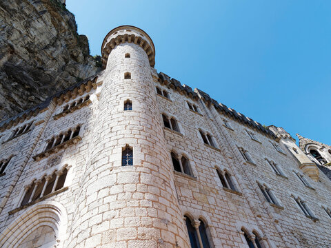 Rocamadour Sanctuary with numerous religious monuments and crypt decorated with towers, arched windows and crenellated walls around a square 'Parvis des Eglises'
