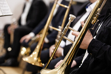Trombones in the hands of musicians in an orchestra