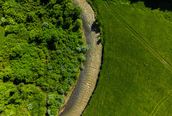 Aerial view of the Tarnava Mica river with salt-polluted water from the Praid salt mine - Romania. The place where the Corund stream flows into the Tarnava Mica river polluted with salt