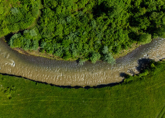 Aerial view of the Tarnava Mica river with salt-polluted water from the Praid salt mine - Romania. The place where the Corund stream flows into the Tarnava Mica river polluted with salt