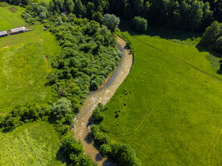 Aerial view of the Tarnava Mica river with salt-polluted water from the Praid salt mine - Romania. The place where the Corund stream flows into the Tarnava Mica river polluted with salt