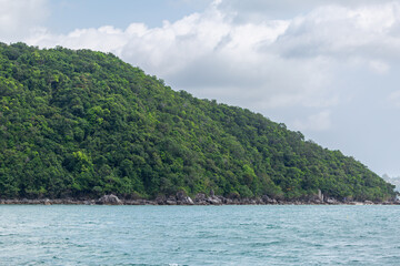 Koh Samui beach, Image shows a remote beach along the coastline of Ko Samui mainland showing the tropical tree covered hills from a boat