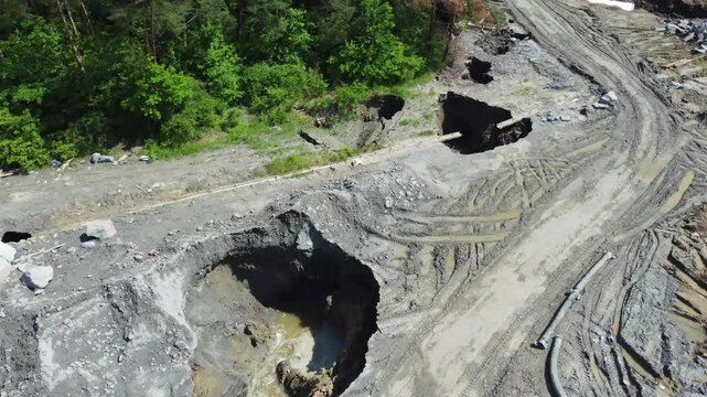 Aerial filming of the place where the ground collapsed, forming holes due to the erosion of the ceiling of the salt mine in Praid - Romania