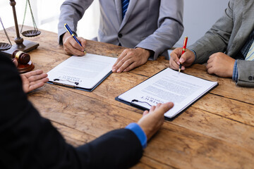 Lawyer mediating dispute, two litigants and businessmen in law office. Signing a contract agreement...