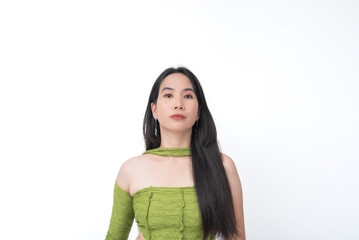 Young woman in asymmetrical green ruched top stares ahead with a neutral and slightly unamused...
