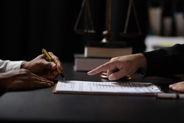 Lawyer reviewing contract agreement with legal documents, Discussing contract agreement at desk with legal document.
