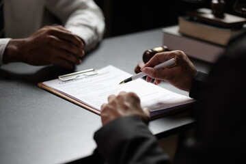 Lawyer reviewing contract agreement with legal documents, Discussing contract agreement at desk with legal document.