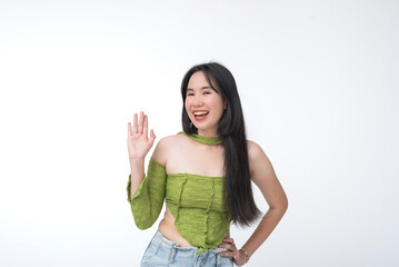 Energetic Filipina girl waves hello and brimming with enthusiasm while dressed in Gen Z green...