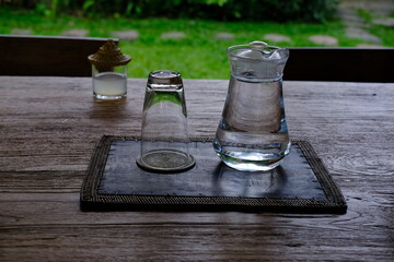 Glass Carafe with Water and Upside-Down Glass on Wooden Table