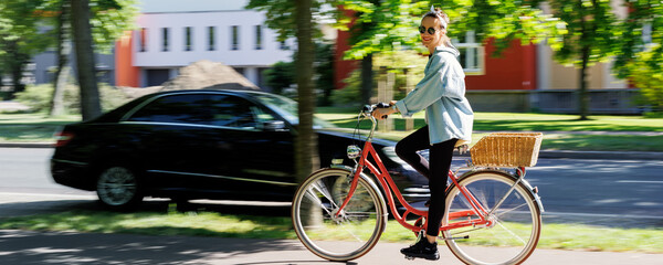 Portrait young adult pretty woman with red vintage retro bike and pin-up casual outfit green city park bright sunny summer day. Happy beautiful female person cycling outdoors. Healthy lifestyle