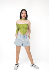 Filipina teenager stands in a thoughtful, pensive stance with hands in denim pockets, serious and...