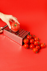 Creative Tomato Grating Concept with Cherry Tomatoes on Red Background