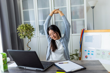 Young Thai Woman Working from Home Stretching Due to Exhaustion..
