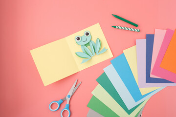 DIY paper frog on pink flat lay ideal for kids crafts guide, learning platforms, art lessons,...
