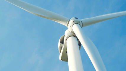 Close-up of a windmill generating renewable energy against a blue sky on a beautiful spring day. Alternative renewable energy. Concern for the environment and climate change.