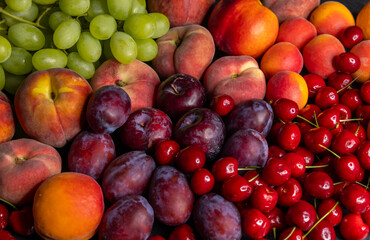Ripe summer fruits arranged on a surface, showcasing vibrant colors and textures