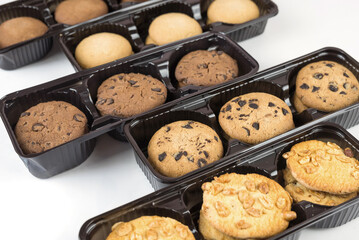 Various round cookies in an open box. Cookies in a pack on white