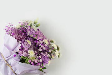 Bouquet of different purple flowers as a gift, white background. Gift for a holiday, Women's Day, Wedding, Mother's Day, March 8.