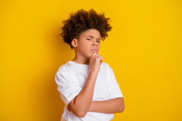 Confident young boy considers decision while displaying thoughtful expression against vibrant...