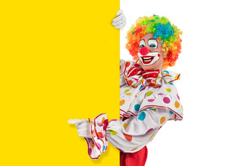Funny clown with blank template mockup, man entertainer as Joker in a suit and wig, with clown whiteface makeup. Trickster, jester, pantomime, mime, and a professional actor at events, birthday party