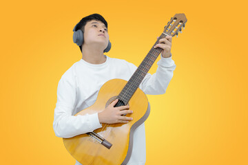 Obraz premium man playing acoustic guitar with headphones against orange background
