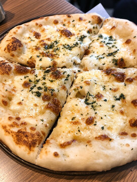 Indian naan bread with garlic butter and sauces on wooden table. AI Generative.