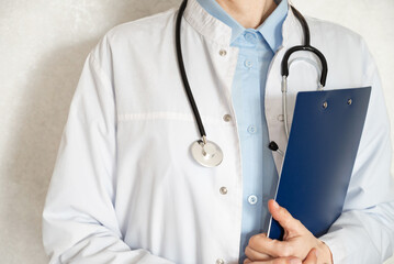 Healthcare professional taking notes in a clinical setting during a routine check-up