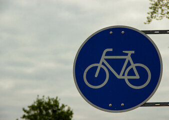 Bicycle lane traffic sign with a white bike symbol on a blue background, indicating designated...