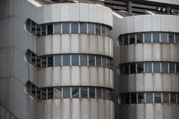 Futuristic round building with sleek gray metal facade and continuous horizontal windows. Modern...