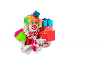 Funny clown with gifts, man entertainer as Joker in a suit and wig, with clown whiteface makeup. Trickster, jester, pantomime, mime, and a professional actor at events, birthday party