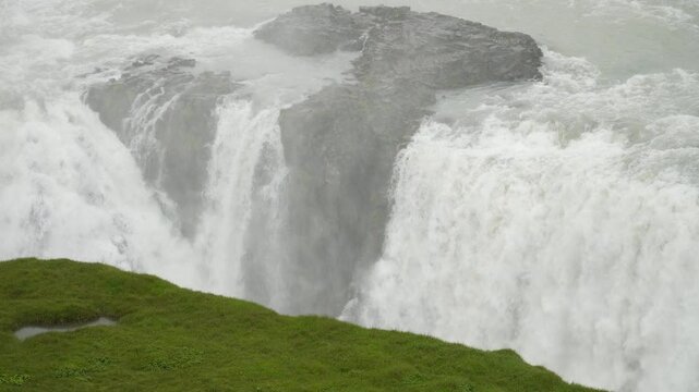 A powerful close-up of Gullfoss waterfall in Iceland shows water surging over jagged basalt rocks. The video captures the raw force and energy of the cascade in this iconic natural wonder.