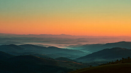 Obraz premium Serene misty sunrise over rolling hills creates tranquil landscape with soft hues of orange and blue, evoking sense of calm and peace
