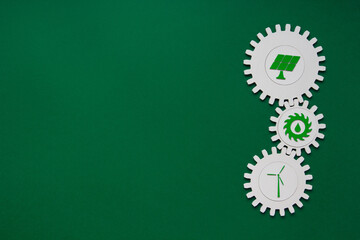 Connected gear wheels with renewable energy icons on green background. Solar, hydroelectric and...
