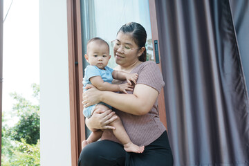At home, a baby plays with their parents and aunt, sharing moments of laughter and occasional tears. The lively atmosphere reflects the warmth, joy, and emotional ups and downs of family life.
