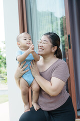At home, a baby plays with their parents and aunt, sharing moments of laughter and occasional tears. The lively atmosphere reflects the warmth, joy, and emotional ups and downs of family life.
