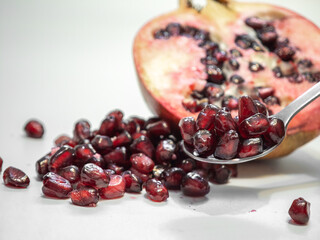 Ripe pomegranate, cut fruit, red seeds close-up