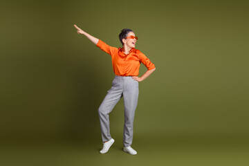 Confident woman in casual attire posing joyfully against a khaki background showcasing style and personality