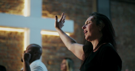 Woman in deep worship, raising her hand with eyes closed in prayer, emotional connection, Christian...