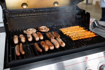 Grill mit Bratwürsten und marinierten Spießen