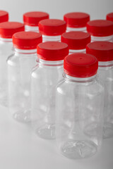 several plastic bottles with red caps in close-up on a white background.