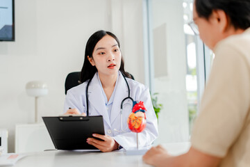 Female doctor uses heart model to give advice on heart disease and heart disease treatment....