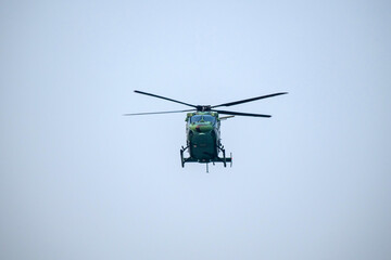 Helicopter is flying on isolated blue sky in mid-air background