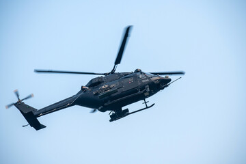 Helicopter is flying on isolated blue sky in mid-air background