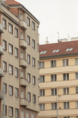 Fototapeta premium Two adjacent residential buildings in a vibrant urban scene feature unique architectures, with inviting balconies and modern facades that enhance the lively city environment