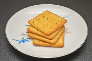 cream crackers on a plate on a black background