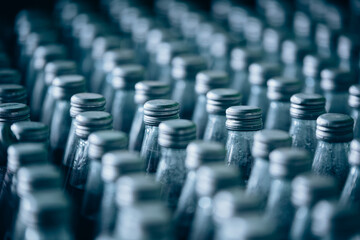 Multiple bottles of fruit juice are arranged in rows, creating a colorful and organized background. The image showcases various flavors and vibrant packaging, commonly seen in beverage production