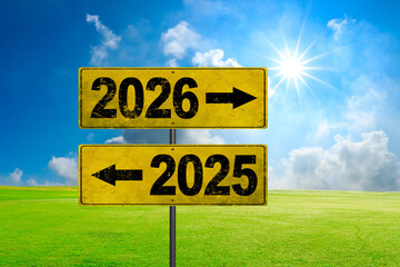 Road signs indicate the path to the new year 2026 and the old year 2025 on a blue sky, creative...