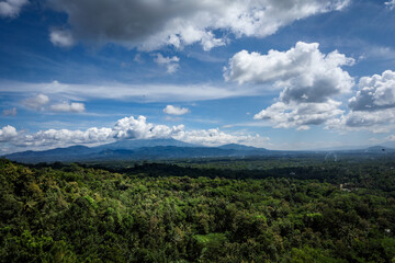 Naklejka premium Mountain landscape with volcano Merapi and green dense rainforest in Jawa, Indonesia.