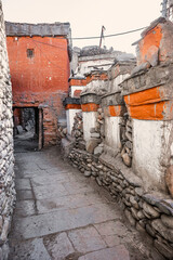 Mani wall with "Om mani padme hum" ("she of the lotus jewel") mantra written on prayer wheels. Kagbeni Street in winter. Mustang, Nepal, Annapurna circuit trek or Jomsom trek.