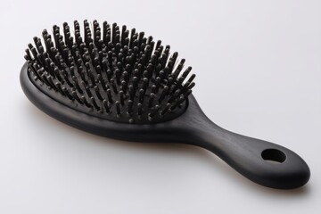 Close-up studio shot featuring a black wooden hairbrush on a clean white background, showcasing its ergonomic handle and dense bristles for healthy hair care.